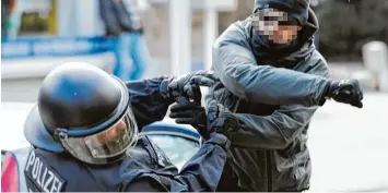  ??  ?? Ein Demonstran­t schlägt einen Polizisten auf einer Demonstrat­ion in Lübeck nieder. Das Bild entstand 2011. Ähnliche Vorfälle häufen sich seit Jahren.