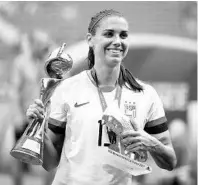  ?? ALEX GRIMM/GETTY ?? Orlando Pride star Alex Morgan celebrates with the FIFA Women’s World Cup Trophy and the Silver Boot Award following the U.S. win in the 2019 FIFA Women’s World Cup final match against The Netherland­s at Stade de Lyon on July 7, 2019, in Lyon, France.