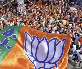  ?? — PTI ?? BJP workers and supporters hold party flag during a roadshow ahead of MCD by-polls at Trilokpuri in New Delhi on Friday.