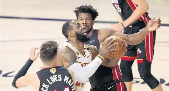  ?? MARK J. TERRILL/AP PHOTOS ?? The Lakers’ LeBron James meets up with the Heat’s Tyler Herro and Jimmy Butler on Saturday in a rematch of last season’s NBA Finals.