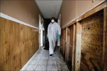  ?? GREGORY BULL — THE ASSOCIATED PRESS ?? Donald Charles wears a protective suit and mask as he cleans out his parents’ flood-damaged home Saturday in Houston. Thousands of people have been displaced by torrential rains and catastroph­ic flooding since Harvey slammed into Southeast Texas last...