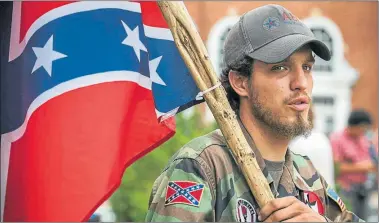  ?? FOTOS: CEDOC PERFIL ?? SIMBOLOS. Una bandera confederad­a y una de las polémicas marchas racistas, en la universida­d de Virginia.