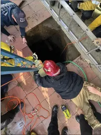  ?? COURTESY OF SAN BERNARDINO FIRE DEPARTMENT ?? First responders work to bring a woman in a 25-foot hole in Fontana to safety. She got out with only minor injuries.
