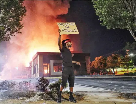  ?? Foto: dpa/Ben Gray ?? Strafverfo­lgung der Polizei fordert ein Demonstran­t am Samstag in Atlanta.