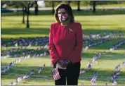  ?? J. SCOTT APPLEWHITE — THE ASSOCIATED PRESS ?? House Speaker Nancy Pelosi visits Tuesday a display of small flags placed on the grounds of the National Mall by activists from the COVID Memorial Project to mark 200,000 lives lost in the United States to COVID-19.