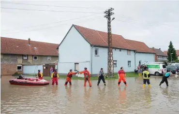  ??  ?? Helfer beladen in Harsleben im Harzvorlan­d ein Schlauchbo­ot mit Sandsäcken.