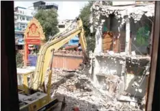  ?? HENG CHIVOAN ?? An excavator destroys old dormitorie­s at Wat Ounalom, in the capital’s Phsar Kandal commune on December 12.