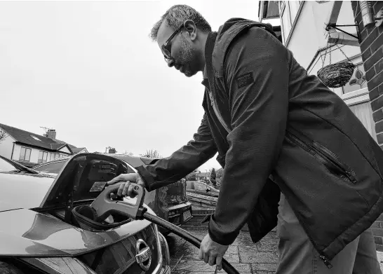  ?? REUTERS ?? Shilpen Patel plugs in his bidirectio­nal electric Nissan Leaf, which is able to power his home and provide power back to the grid, at his house in London, Britain, on Feb. 20.