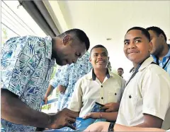  ?? Picture: ATU RASEA ?? Fijian Drua winger Taniela Rakuro signs his autograph with students of LDS Technical College during their visit to the Australian High Commission­er’s residence in Suva yesterday.