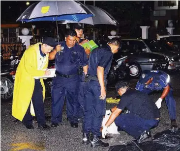  ??  ?? Hard landing: A forensic team conducting preliminar­y investigat­ions at the spot where Qie had fallen at the apartment block in Lintang Paya Terubong.