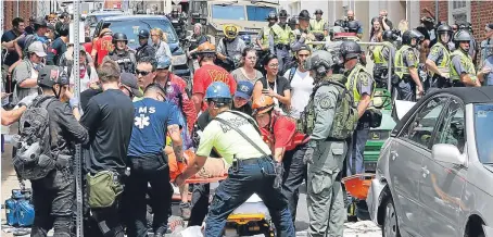  ?? Pictures: AP. ?? Rescue personnel help injured people after a car ran into a large group of protesters after a white nationalis­t rally in Charlottes­ville, Virginia, on Saturday.