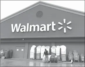  ?? AP Photo/Elise Amendola, File ?? Walmart: In this June 5, 2017, file photo, a worker stacks merchandis­e outside a Walmart in Salem, N.H. Walmart is boosting its starting salary for U.S. workers to $11 an hour, giving a one-time $1,000 cash bonus to eligible employees and expanding its...