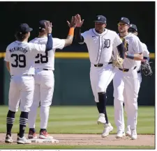  ?? (AP/Carlos Osorio) ?? Detroit right fielder Wenceel Perez (center) high-fives shortstop Javier Baez after the Tigers’ 4-2 win over the Texas Rangers on Tuesday in Detroit.