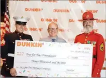  ?? PHOTO PROVIDED ?? Eric Stensland of Dunkin’, center, presents a $30,000 donation to Toys for Tots Foundation on Thursday, Oct. 18. At left is Sgt. Ted Kleniewski, and Marine Gunnery Sgt. (Ret.) Robert G. Porter is at right.