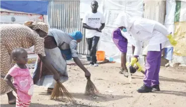  ??  ?? Africa team helping IPDs in Durunmi, Abuja to clean their environmen­t recently