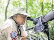  ?? ASHLEY MIZNAZI amiznazi@miamiheral­d.com ?? Brent Smith looks through a microscope at Audubon Corkscrew Swamp Sanctuary at ghost orchids up in the cypress trees.