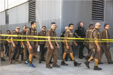  ?? Photos by Gabrielle Lurie / The Chronicle 2017 ?? UPS workers evacuate their building after a shooting rampage in San Francisco on June 14. Since then, the company has tightened its policies on metal detectors and bag checks, several workers said.