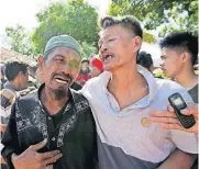  ?? [AP PHOTO] ?? Relatives react as rescue teams recover the bodies of victims killed in an earthquake Tuesday in North Lombok, Indonesia.