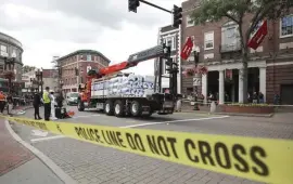  ?? NICOLAUS CZARNECKI / HERALD STAFF ?? ROADS’ TOLL: Accident investigat­ors work in Harvard Square, where a truck hit a pedestrian, who later died.