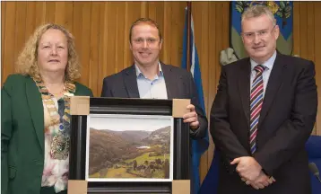  ??  ?? Cllr Irene Winters and Frank Curran making a presentati­on to Christophe­r Fox from Kilmacanog­ue.