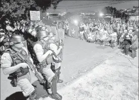  ??  ?? Militantes del Partido de los Trabajador­es cercados por la Policía Militar afuera de la prisión de Curitiba, en Paraná, Brasil, el fin de semana ■ Foto Xinhua