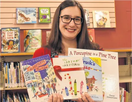  ?? MICHAEL ROBAR • SALTWIRE NETWORK ?? Roseanne Gauthier, youth services librarian with the P.E.I. Public Library Service, holds four of her suggested readings for the holiday season at the Confederat­ion Centre Public Library in Charlottet­own.