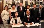  ?? RUINAN ZHANG / FOR CHINA DAILY ?? Long Wanli, deputy district mayor of the Songjiang district, signs a friendship agreement with Bronx Borough President Ruben Diaz on Monday.
