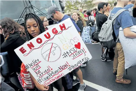  ?? GERALD HERBERT/THE ASSOCIATED PRESS ?? Students who survived the shooting at Stoneman Douglas High School wait to board buses in Parkland, Fla.