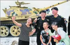  ?? ZOU HONG / CHINA DAILY ?? Visitors take photos with Russian soldiers at the Internatio­nal Army Games 2017 in Korla, Xinjiang Uygur autonomous region.