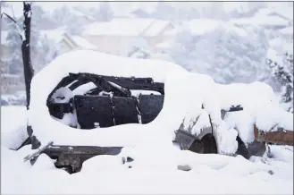  ?? David Zalubowski / Associated Press ?? The remains of a vehicle destroyed by a pair of wildfires is draped by nearly a foot of snow Saturday in Superior, Colo. An overnight dumping of snow and frigid temperatur­es compounded the misery of hundreds of Colorado residents who started off the new year trying to salvage what remains of their homes after a wind-whipped wildfire tore through the Denver suburbs.