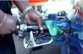  ??  ?? Fuel station attendant dispensing petrol.