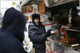  ?? SETH WENIG — THE ASSOCIATED PRESS ?? In this Nov. 21 photo, Mohammed Shaheedul Huq serves a customer from his food cart in Brooklyn last Monday.