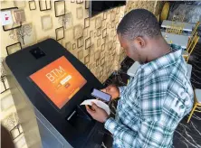  ??  ?? A bitcoin user checks receipts after buying the cryptocurr­ency in Lagos. A weaker Nigerian naira is pushing US dollars out of reach for many. Reuters