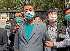  ?? AP ?? Media tycoon Jimmy Lai, centre, is arrested by police officers at his home in Hong Kong on Saturday. Police arrested at least 14 pro-democracy lawmakers and activists on charges of joining unlawful protests.