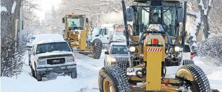  ?? GAVIN YOUNG ?? City graders make their way around cars parked in the snow ban area along 12th Avenue N.W. on Tuesday afternoon.