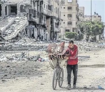  ?? ?? A homeless man walks past destroyed buildings in Gaza where Brendan O’hara visisted