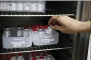  ?? BOB EDME — THE ASSOCIATED PRESS ?? A woman picks up a vial of AstraZenec­a vaccine from the box “Tuesday” from a fridge while a box “Monday” is seen at left, in a vaccinatio­n center in Saint-Jean-de-Luz, southweste­rn France on Tuesday.