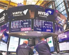  ?? (Michael M. Santiago/Getty Images) ?? TRADERS WORK on the floor of the New York Stock Exchange last week.