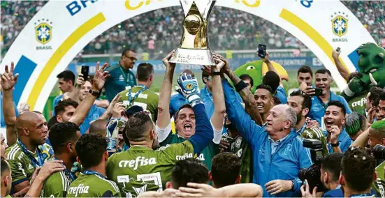  ?? Robson Ventura/Folhapress ?? O presidente eleito, Jair Bolsonaro, levanta a taça do Campeonato Brasileiro dada ao Palmeiras, que venceu o Vitória no Allianz Parque