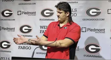  ?? CHIP TOWERS/CTOWERS@AJC.COM ?? Georgia offensive lineman Tate Ratledge points to a “DW” tattoo on the inside of his right wrist. Those are the initials of his former teammate, Devin Willock, who died in a car crash Jan. 15.