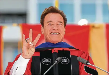  ?? Steve Gonzales / Houston Chronicle ?? Arnold Schwarzene­gger gives the Cougar Paw during the University of Houston commenceme­nt address Friday at TDECU Stadium.