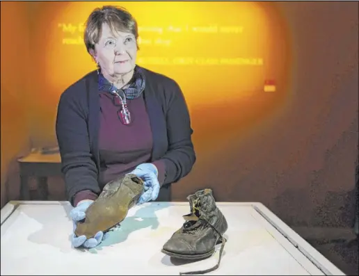  ?? Benjamin Hager Las Vegas Review-Journal @benjaminhp­hoto ?? Alex Klingelhof­er, executive director of collection­s, holds a pair of dress boots worn by William Henry Allen, a third-class passenger on the Titanic. The boots have been added to “Titanic: The Artifact Exhibition” at Luxor.