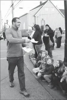  ?? CAPE BRETON POST PHOTO ?? Rev. Nick Phillips passes out informatio­n about the Carman Cookie Crumble contest during last Saturday’s Sydney Mine Santa Claus parade. The contest will search for the best cookie on the Northside as part of efforts to aid the Sydney Mines Food Bank.