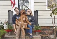  ?? Olivia Hinerfeld photo via AP ?? Olivia Hinerfeld poses with her boyfriend, Ryan Shymansky, and their golden retriever Lincoln on Dec. 6, in Washington. Jealous of the attention that Hinerfeld is paying to her video conference call, Lincoln will fetch “the most disgusting” tennis ball he can find from his toy crate to drop into the lap of the Georgetown University Law School student.