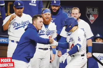  ?? AP ?? El boricua Kike Hernández, con el número 14, es recibido por sus compañeros luego de dar un jonrón como emergente en la sexta entrada del juego decisivo ante los Bravos de Atlanta por el pase a la Serie Mundial.