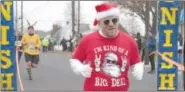  ?? SUSAN KEEN — DIGITAL FIRST MEDIA FILE PHOTO ?? Jeff Jansen gives a thumbs up as he crosses the finish line at the 2012 Reindeer Run.