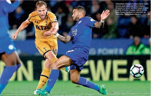  ?? — AP ?? Tottenham Hotspur’s Harry Kane (left) shoots past Leicester City’s Danny Simpson to score his third goal in their English Premier League match at the King Power Stadium in Leicester on Thursday. Tottenham won 6-1.
