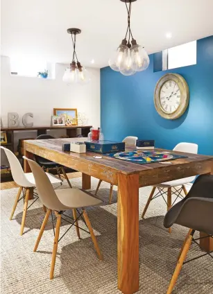  ??  ?? Côté salle de jeu, les ados ont participé au choix du mobilier et des accessoire­s en fonction de leurs goûts, introduisa­nt plusieurs genres. Le choix d'une table en bois rustique qui intègre des touches de bleu assure une parfaite harmonie avec le mur d'accent.
