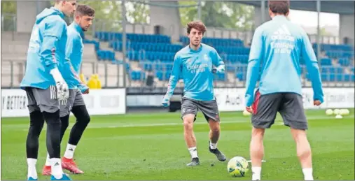  ??  ?? Odriozola, entrenándo­se en Valdebebas la semana pasada junto a Valverde y Lunin (a la izquierda) y Nacho, de espaldas.