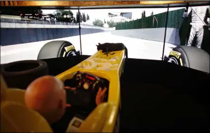  ??  ?? When he’s not writing best-sellers, Terry Goodkind enjoys racing cars. Here, with his cat riding lookout, Goodkind goes for a spin in a racing simulator at his Southern Nevada home.